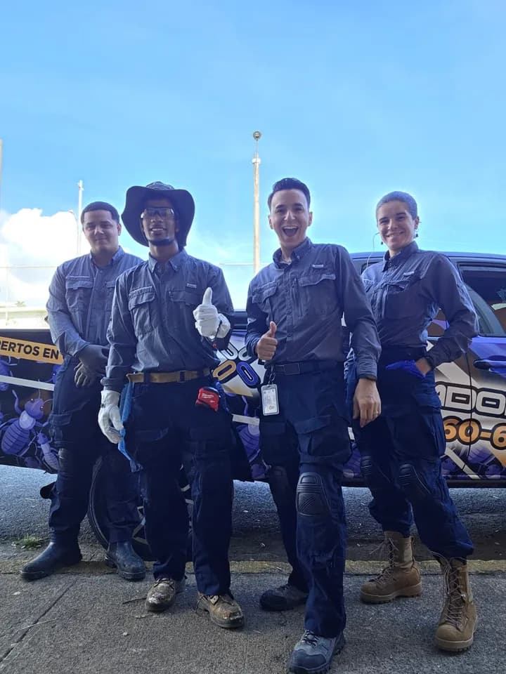 Equipo de Exterminadores PR junto al vehículo rotulado de la empresa