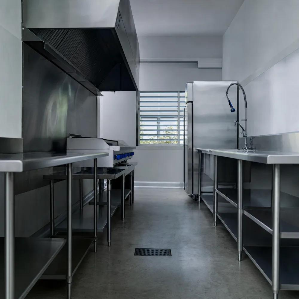 Cocina industrial vacía en acero inoxidable con zócalo sanitario